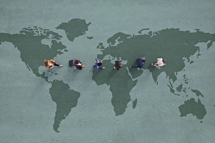 business-people--walking-across-world-map-900x600